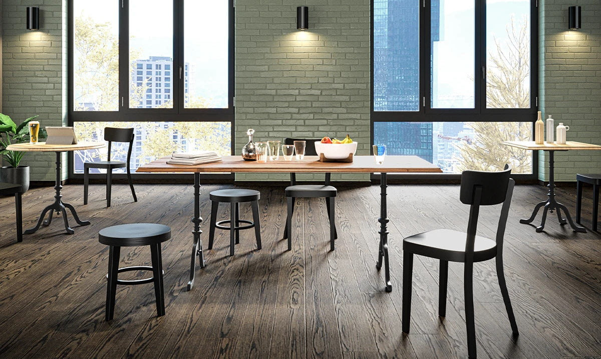 Modernes Restaurant in Zürich mit Beizentisch aus Massivholz schwarzen Stühlen und Hockern vor großen Fenstern mit Stadtblick